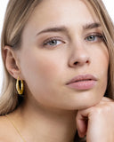 Créoles en argent doré portées