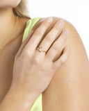 Bague en argent doré sertie d’une pierre claire portée, gros plan