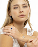 Bracelet, bague et dormeuses trèfle en argent portés